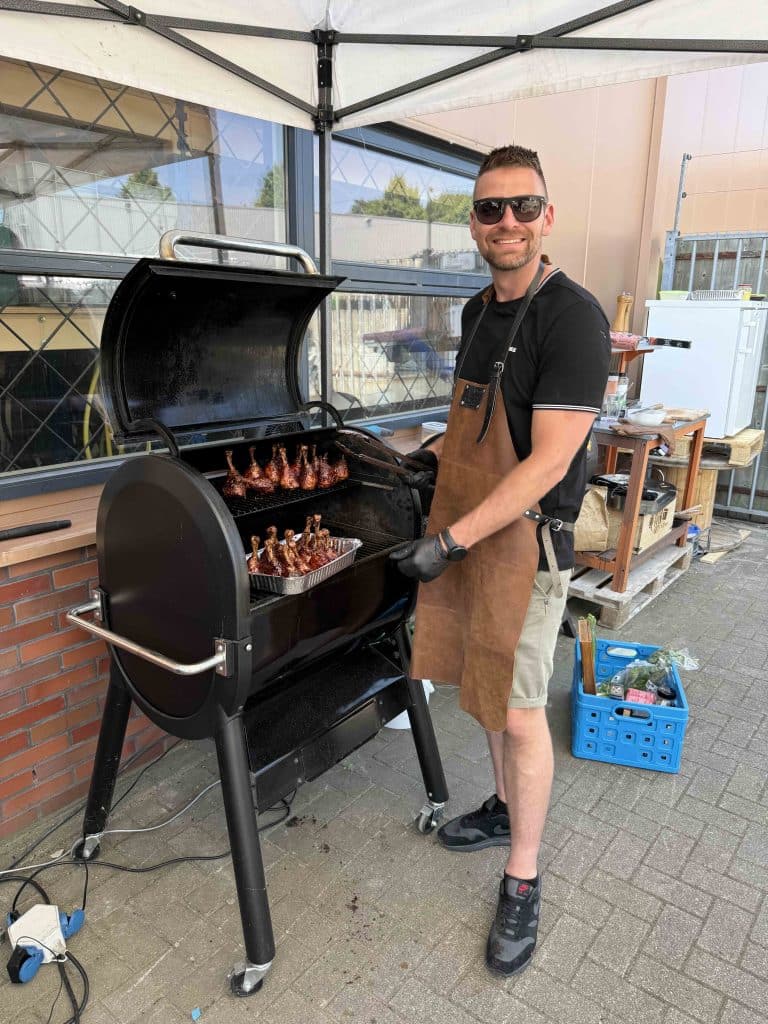 Collega bij de barbecue tijdens een teamdag