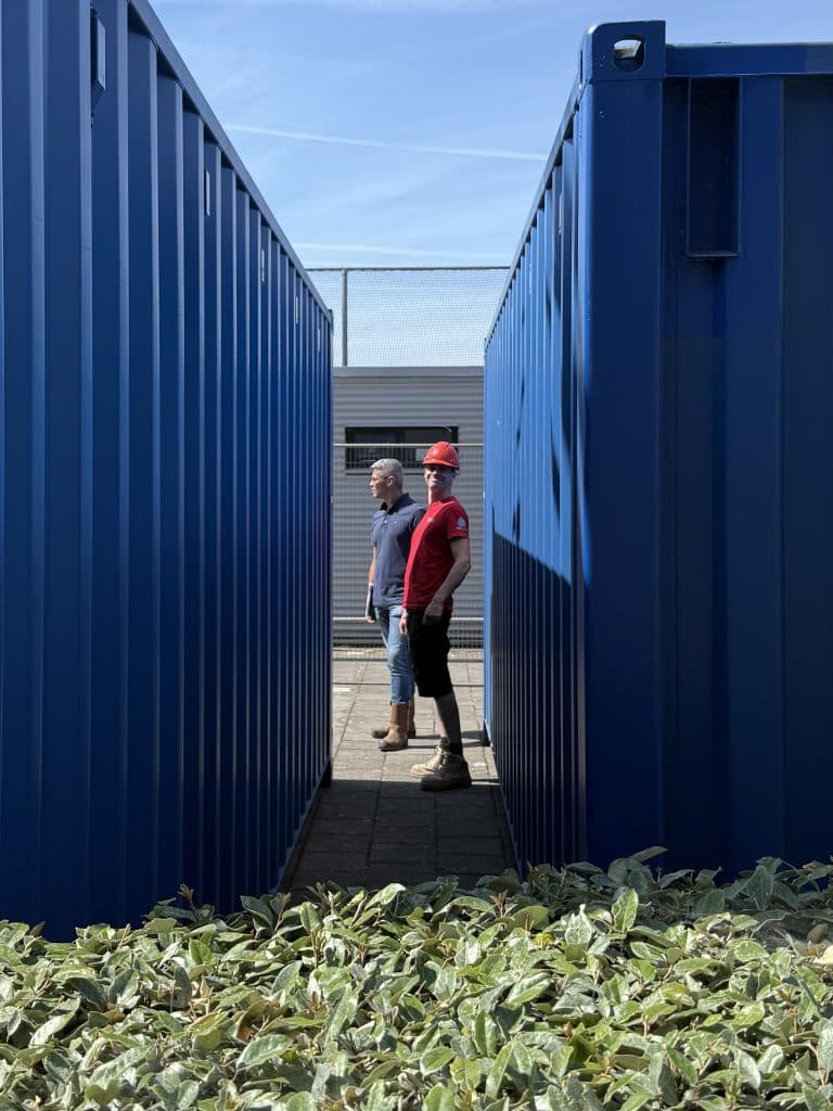Monteur tussen de containers op een bouwplaats